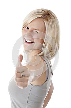 Attractive blonde woman holds thumb up and winks