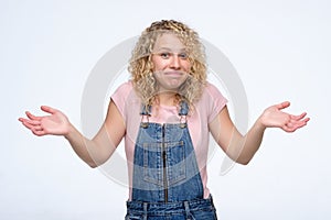 Attractive blonde woman shrugging her shoulders. I do not know how it happened