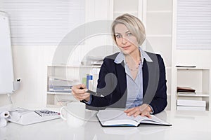 Attractive blonde woman sitting at desk.