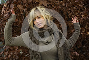 Attractive blonde young woman against autumn leaves