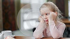 Attractive boring blonde female child falling asleep after breakfast. Shot with RED camera in 4K