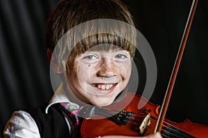 Attractive boy playing violin, studio shooting