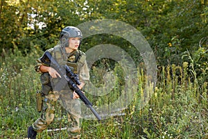 Attractive brave military woman with a gun in forest, survival in wild forest