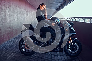 Attractive brave woman is sitting on her motobike in tunnel photo