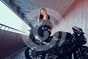 Attractive brave woman is sitting on her motobike in tunnel photo
