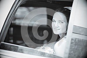Attractive bride in a car