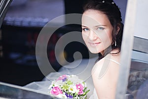 Attractive bride in a car