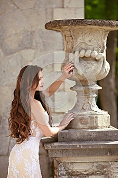 Attractive bride woman wedding portrait, vogue style photo. Fashion brunette model posing in prom white dress by roman flower pot