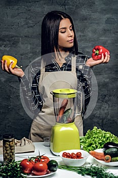 Chef woman holds colorful, sweet peppers.