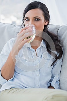 Attractive brunette drinking white wine