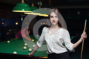 Attractive brunette girl playing billiard game.