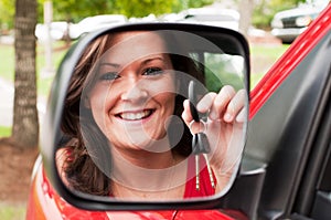 Attractive Brunette Holding Keys in Vehicle Mirror