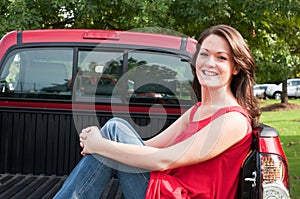 Attractive Brunette Sitting in Bed of Pickup Truck