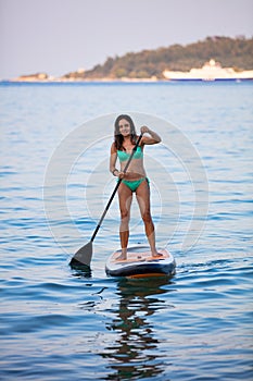 Attractive brunette on a stand up paddle board