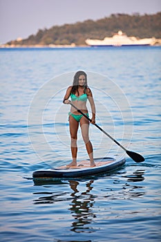 Attractive brunette on a stand up paddle board