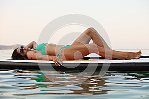 Attractive brunette on stand up paddle board