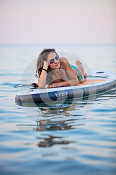 Attractive brunette on stand up paddle board