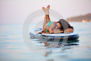 Attractive brunette on stand up paddle board