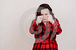 Attractive woman in red dress shows indecent gestures on a white background. photo