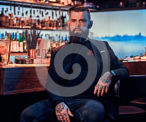 Attractive brutal man is sitting near bar counter