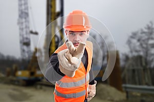 Attractive builder doing I`m watching you gesture