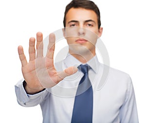 Attractive buisnessman making stop gesture