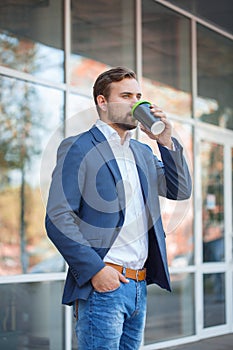 Handsome business man drinking coffee outdoors. photo