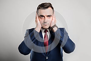 Attractive business man covering ears like deaf gesture