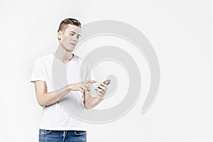 Attractive business man model in white t-shirt isolated on white calling by mobile phone, push buttons hand touching screen.