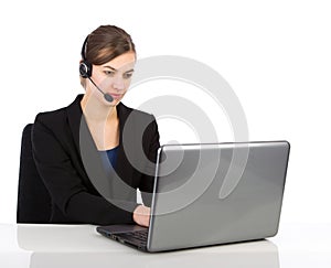 Attractive business woman with headset working on a laptop