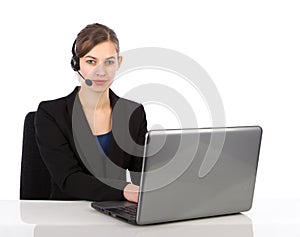 Attractive business woman with headset working on a laptop