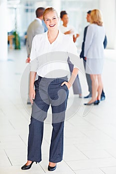 Attractive business woman smiling with business people. Full length of attractive female executive smiling with business