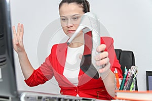 Attractive business woman use smart phone and sitting at her worktable with documents and electronic devices