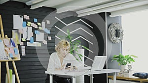 Attractive business woman uses the cell phone in modern office.