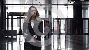 Attractive business woman walking on office building.