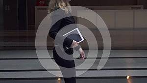 Attractive business woman walking on office building.