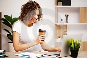 Attractive business woman working on laptop in her workstation.