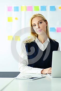 Attractive business woman working on laptop at office. Business people