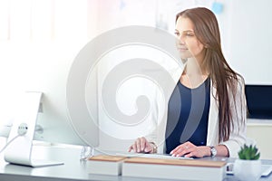 Attractive business woman working on laptop at office. Business people