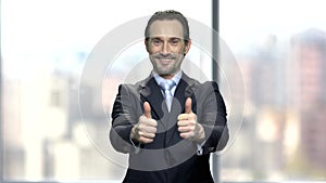 Attractive businessman giving two thumbs up.