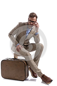 Attractive businessman looking down, wearing eyeglasses, sitting
