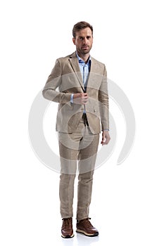 Attractive businessman opening his jacket, looking at the camera