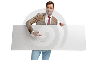 Attractive businessman pointing his finger at his orizontal board