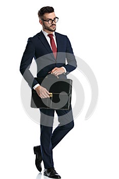 Attractive businessman posing cool with his briefcase on hands