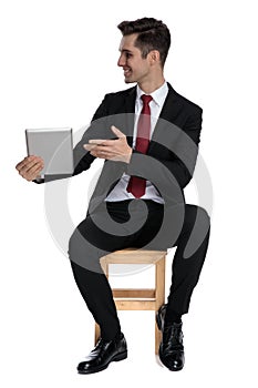 Attractive businessman presenting his tablet to the side