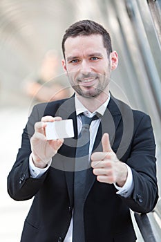 Attractive businessman showing an empty textspace card photo