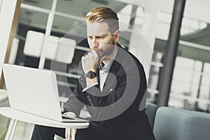 Attractive businessman typing on his laptop at the office