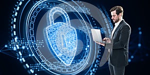 Attractive businessman using laptop with glowing polygonal padlock hologram on blurry dark background. Secure, safety and