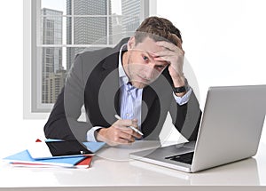 Attractive businessman working in stress at office desk computer