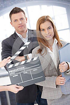Attractive businesspeople with clapper board